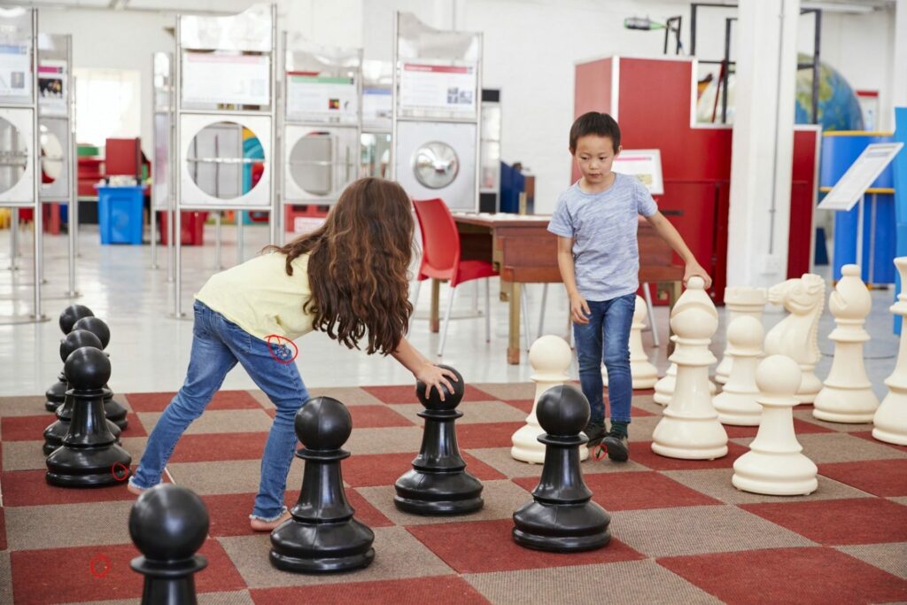 schoolchildren-playing-giant-chess-at-a-science-centre-e1650528925974.jpg